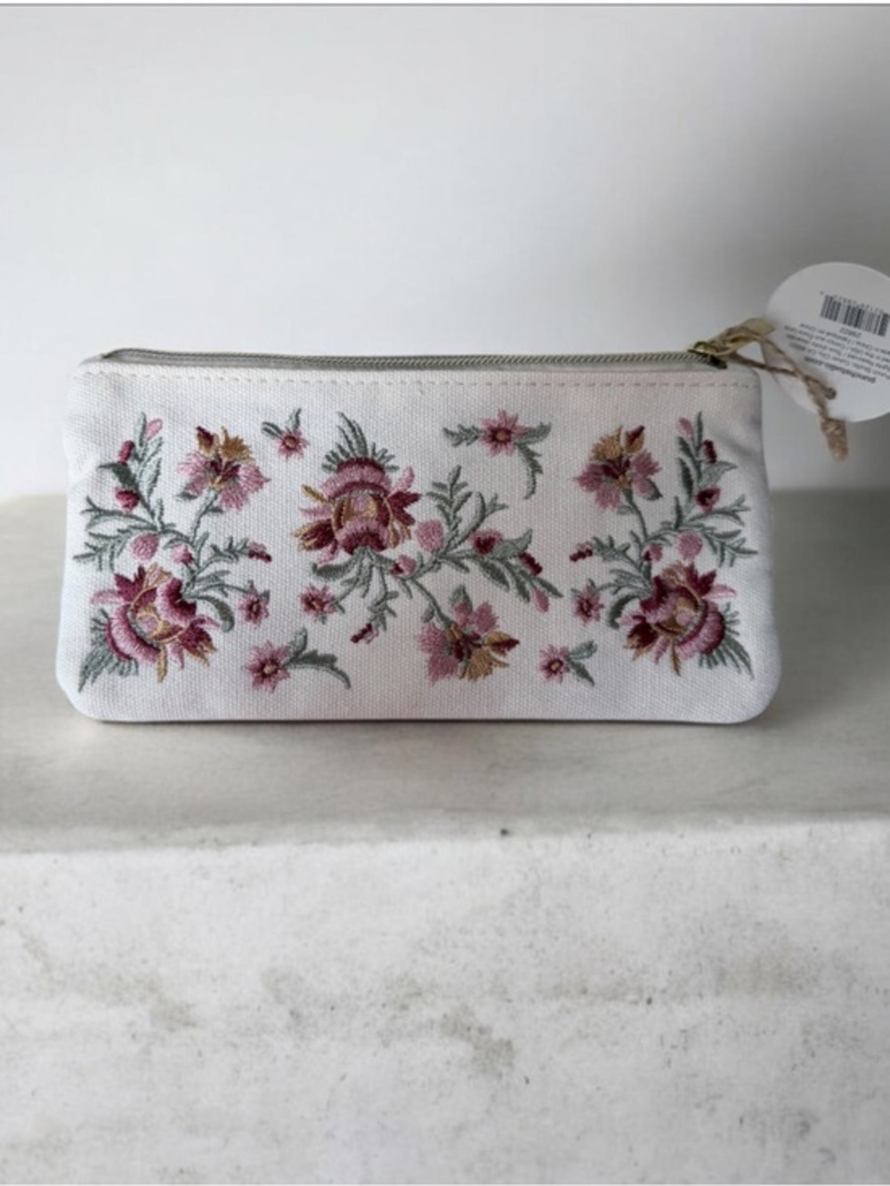 floral embroidered pouch This specific cream-colored canvas pouch Floral design